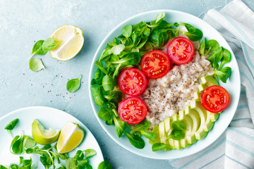 Oatmeal porridge with avocado and vegetable salad of fresh tomatoes and lettuce. Healthy dietary breakfast. Top view
