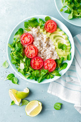 Oatmeal porridge with avocado and vegetable salad of fresh tomatoes and lettuce. Healthy dietary breakfast. Top view