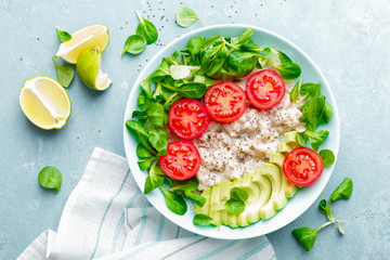 Oatmeal porridge with avocado and vegetable salad of fresh tomatoes and lettuce. Healthy dietary breakfast. Top view