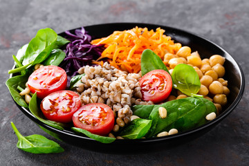 Healthy vegetarian dish with buckwheat and vegetable salad of chickpea, kale, carrot, fresh...