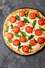 Pizza Margherita with mozzarella cheese, basil and tomatoes Traditional italian food. Classic recipe. Top view