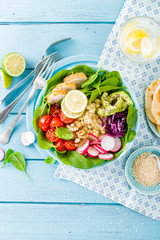 Bowl with grilled chicken meat, bulgur  and fresh vegetable salad of radish, tomatoes, avocado, kale and spinach leaves. Healthy and delicious summer lunch. Top view