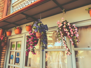 Artificial flowers against the windows of an old building in old Tbilisi