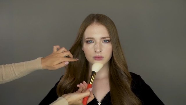 Model girl in front of the camera put makeup