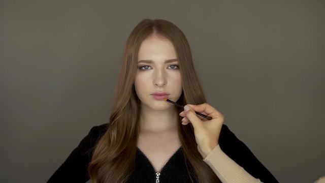 Model girl in front of the camera put makeup