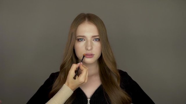 Model girl in front of the camera put makeup