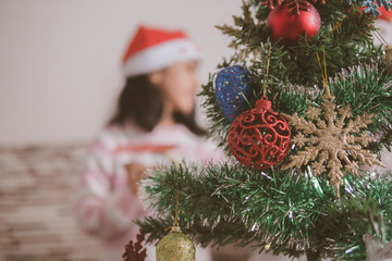 Asian little girl look at the Christmas tree and smile with happines