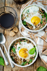 Spinach mushrooms baked egg on a wood background