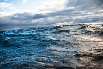 Winter sailing. Cold blue sea at sunset. waves and clouds, Norway