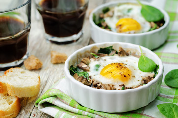 Spinach mushrooms baked egg on a wood background