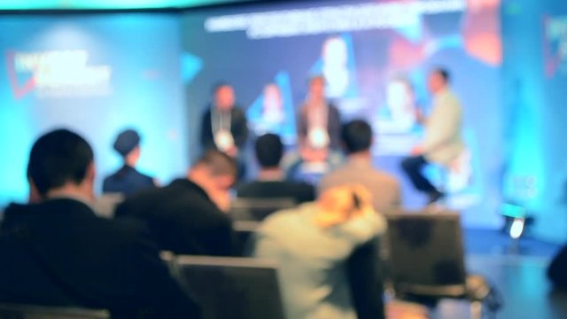 Blurred Background. Many people are sitting in the hall audience listening to presentation lecture speech at forum or conference. Neon lights