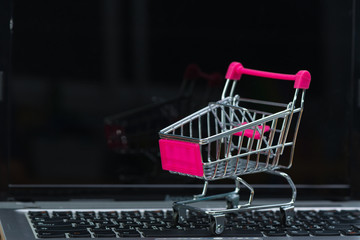 Shopping cart or supermarket trolley with laptop notebook, e-commerce and online shopping concept.