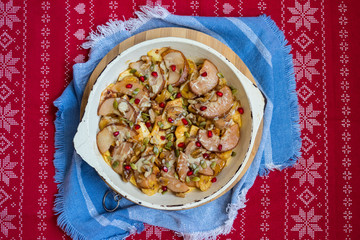 Baked fruits baked in cast iron skillet pan with apples, pears, pomegranate grains, bananas, nuts, pumpkin seeds, natural honey.