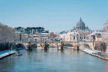 Fototapeta na wymiar Ponte Sant'Angelo and St. Peter's Basilica in the snow, in Rome, Italy.