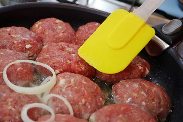 Cooking chops in a frying pan.