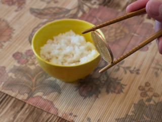 Coin bitcoin on sticks for eating rice and rolls. Bitcoin is everywhere. In the focus, the main object is bitcoin. The concept of a new world currency.