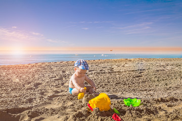 Fototapeta na wymiar kids play with sand on summer beach