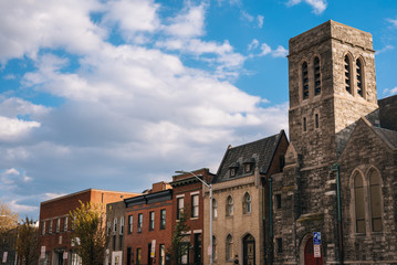 Fototapeta na wymiar A church and row houses on Bank Street in Highlandtown, Baltimore, Maryland