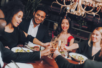 Group of Happy Friends Meeting and Having Dinner