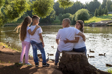 Happy family in the Park. Mom, dad, son and daughter during a walk in a summer