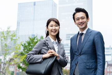 portrait of young asian business person standing in 
front of building