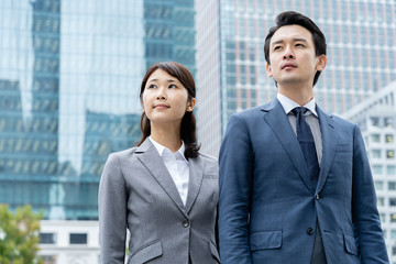portrait of young asian business person standing in 
front of building