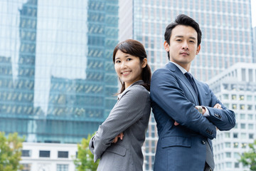 portrait of young asian business person standing in 
front of building