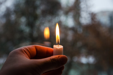 a candle lit in his hand in the dark