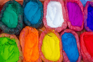 very bright multicolored paint powders in bags and a small spoon. paints for the holiday of Holi.