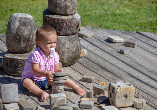 Toddler playing with wooden elements near Seiser Alm, South Tyrol