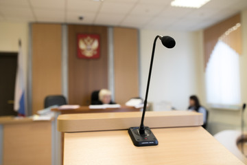 Wooden table in court of law with microphone and gavel