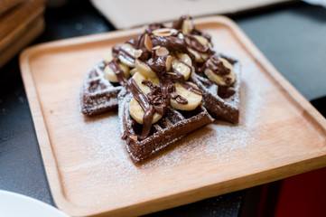 homemade Chocolate waffles with bananas sprinkled and sugar.
