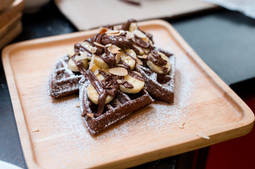 homemade Chocolate waffles with bananas sprinkled and sugar.