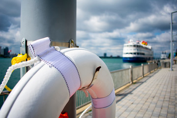 Lifesaver Ring on Detroit Riverfront Walkway with Docked Cruise Ship in Background