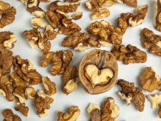 Cleaved walnut and pieces of walnut on a white background.