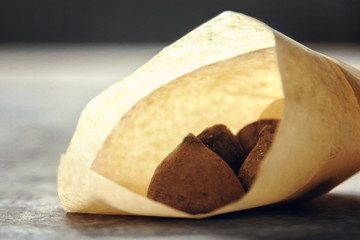 Christmas sack with golden ribbon full of chocolate candies on white background