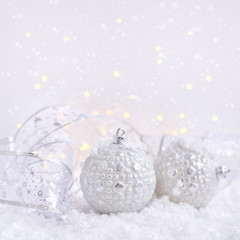 Christmas decorative balls on snow and Christmas lights. Festive Christmas background