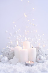 Obraz na płótnie Canvas Christmas candles on the snow and Christmas lights. Festive Christmas background