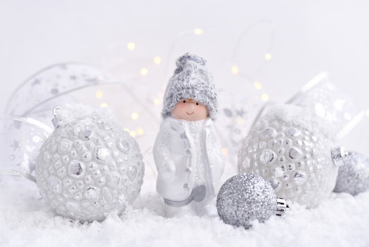 Christmas composition with little figure boy and festive decorations оn the snow. Christmas or New Year greeting card.