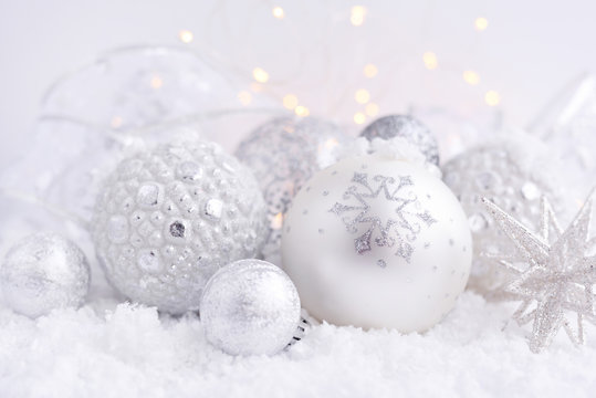 Christmas decorative balls on snow and Christmas lights. Festive Christmas background