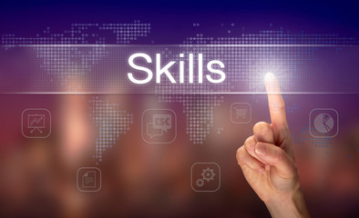 A hand selecting a Skills business concept on a clear screen with a colorful blurred background.