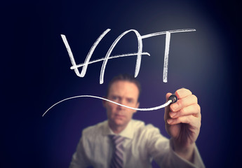 A businessman writing a VAT concept with a white pen on a clear screen.