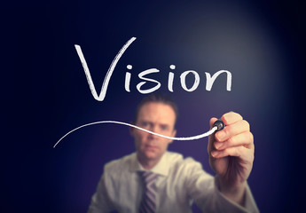 A businessman writing a Vision concept with a white pen on a clear screen.