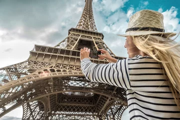 Foto op Canvas Woman tourist selfie near the Eiffel Tower in Paris under sunlight © Andrii IURLOV