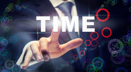 A businessman pressing a Time business concept on a graphical display of cogs