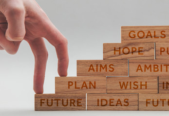 Persons hand walking up a set of  wooden blocks. Business development and growth concept