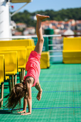 Girl doing cartwheels on Croatian ferryboat in Mali Losinj.