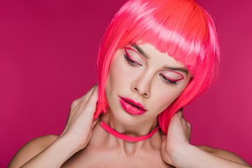 fashionable girl posing in neon pink wig, isolated on pink