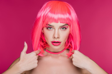 beautiful young woman posing in neon pink wig, isolated on pink