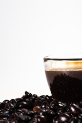 The glass mug of coffee and coffee bean